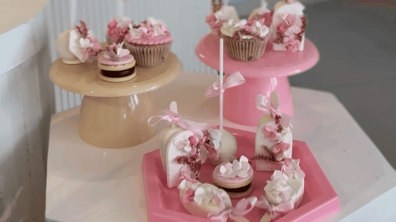Mesa dulce decorada con cupcakes, galletas y elementos decorativos temáticos en colores pasteles.