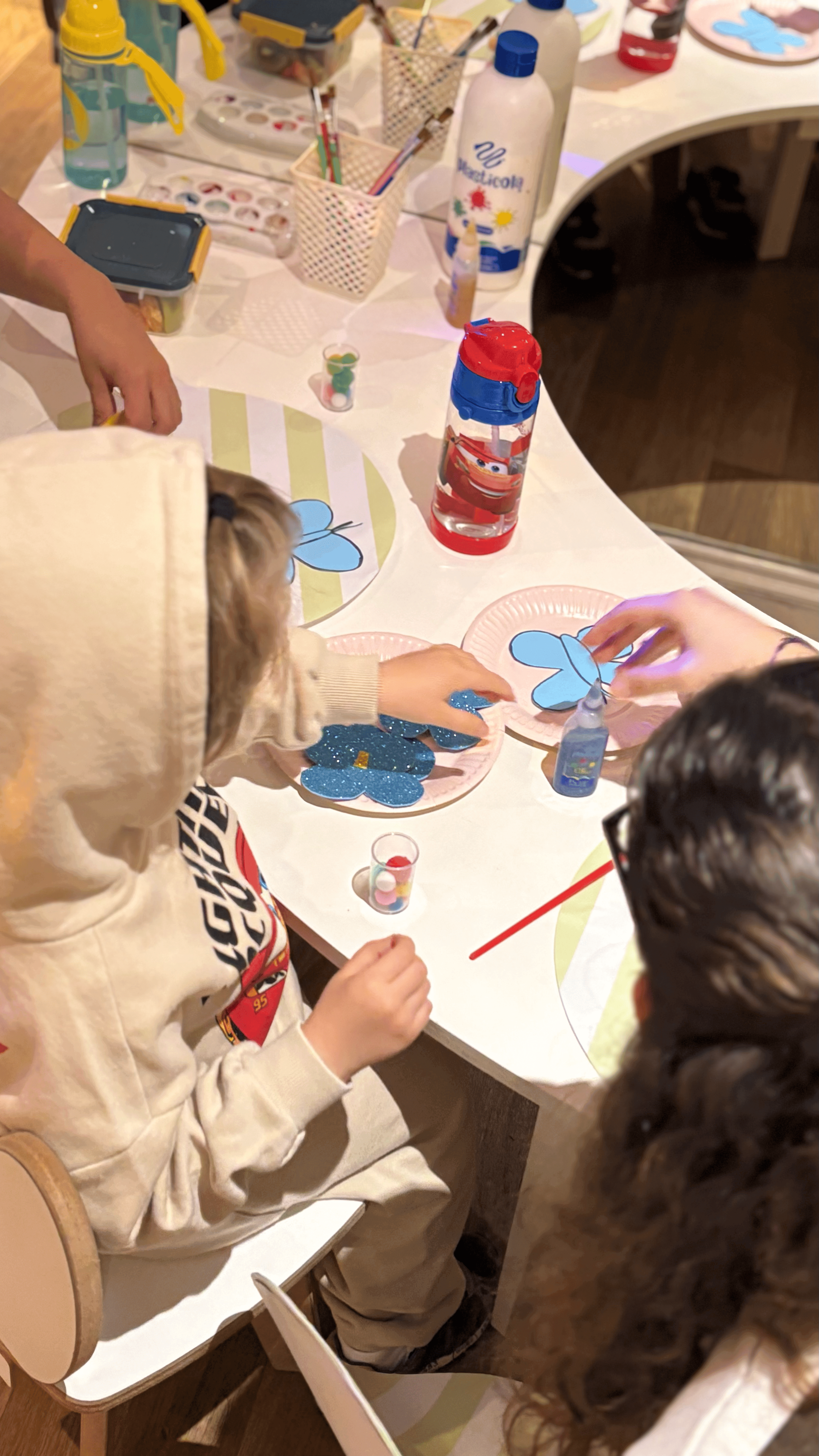 Niños haciendo manualidades junto a la animadora de Matica Eventos.