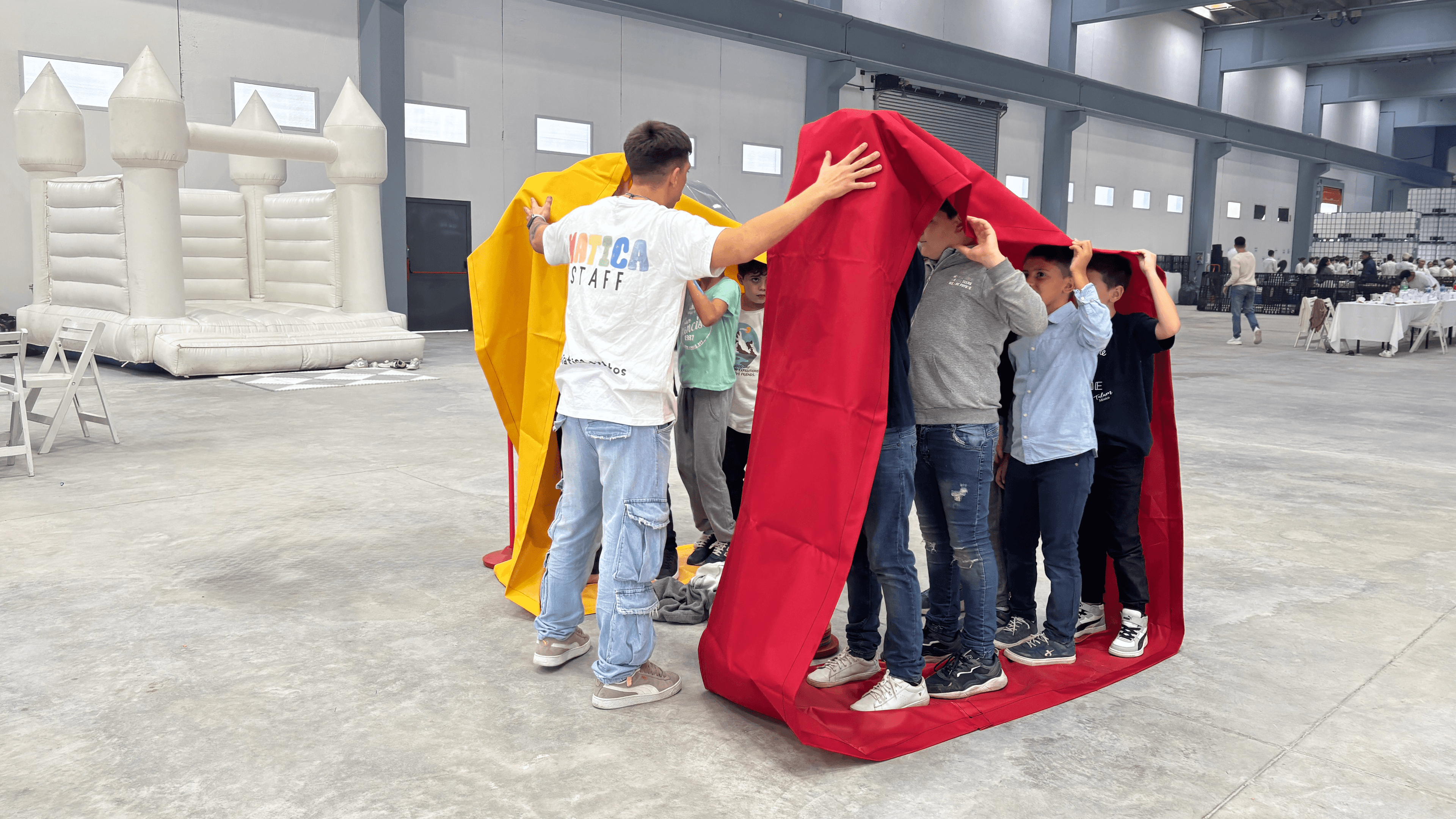 Dos grupos de niños colaborando en un juego en equipo de moverse todos juntos en coordinación.